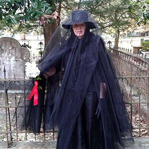 Costumed interpreter in mourning dress at a gravesite
