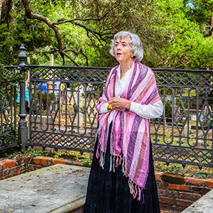 Costumed interpreter by an iron fence